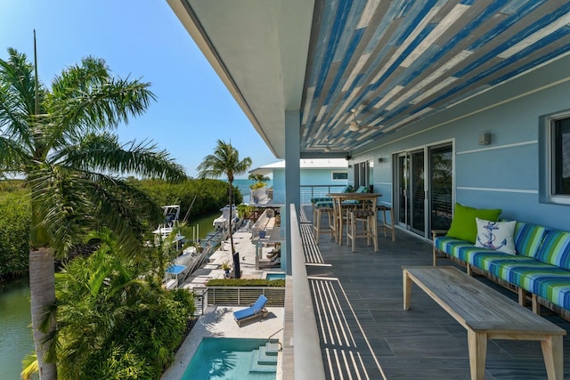 balcony with an outdoor living space, a water view, and outdoor dining area
