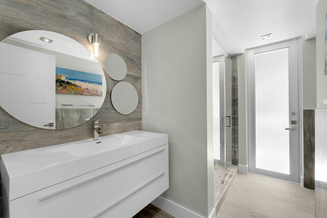 full bathroom featuring tile walls, a shower stall, and vanity