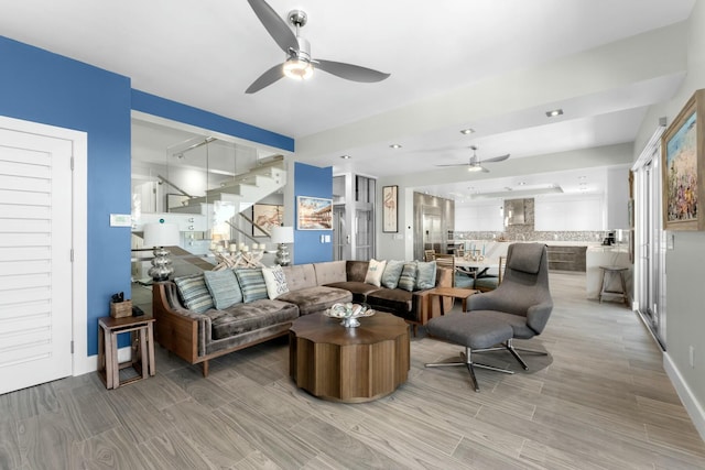 living room featuring a ceiling fan, stairs, and wood finish floors