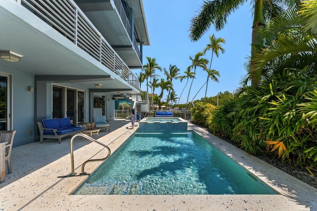 view of swimming pool featuring a pool with connected hot tub and a patio area
