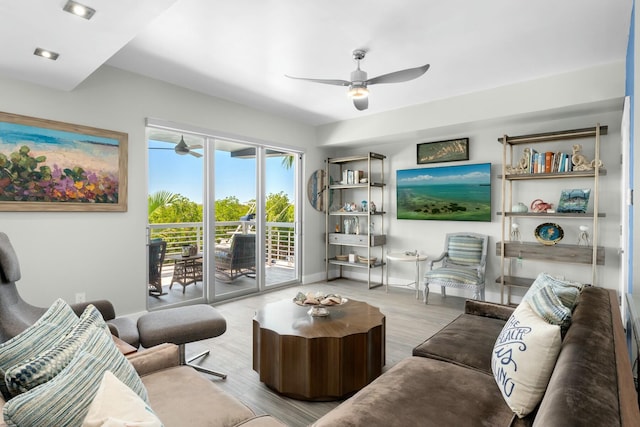 living area featuring baseboards, wood finished floors, and a ceiling fan