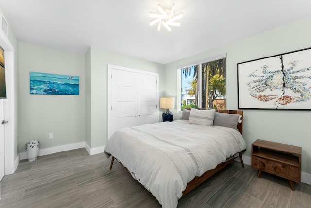 bedroom featuring a closet, visible vents, wood finished floors, and baseboards