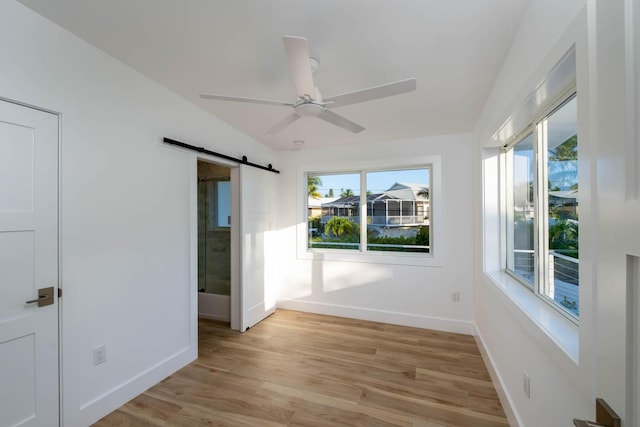 interior space with a barn door and a ceiling fan