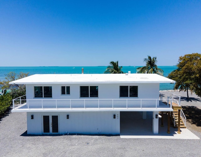 exterior space with french doors, a water view, and stairway