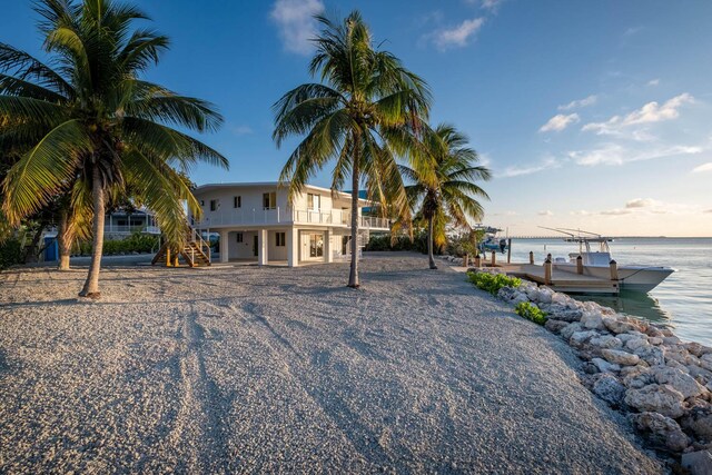 exterior space with a dock, a water view, and stairway