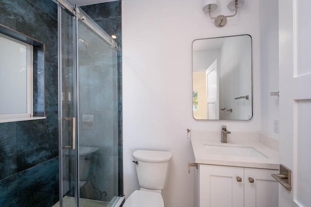 bathroom featuring a stall shower, vanity, and toilet