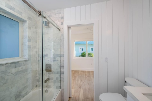 bathroom featuring enclosed tub / shower combo, vanity, wood finished floors, and toilet