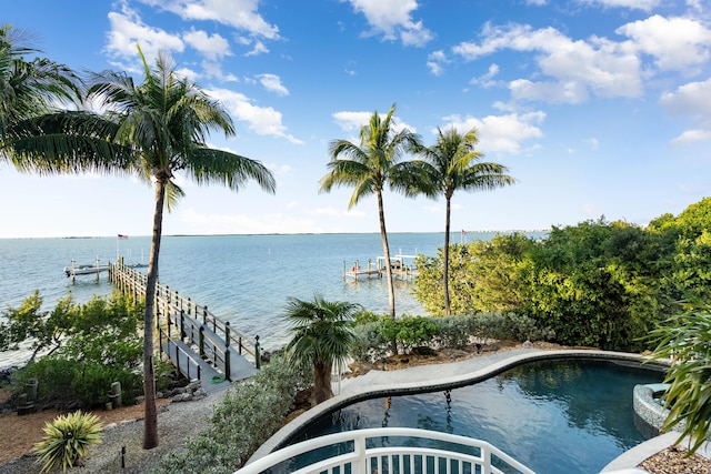 view of swimming pool featuring a water view and a dock