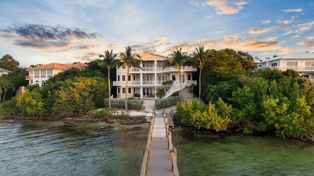 view of dock with a balcony and a water view