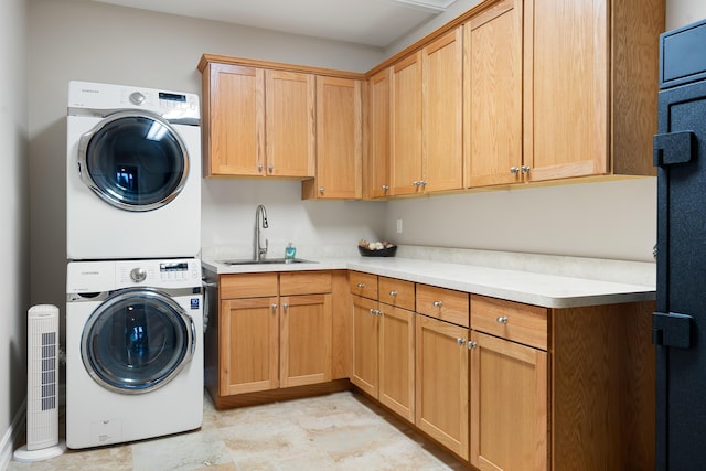 clothes washing area with sink, cabinets, and stacked washer / dryer