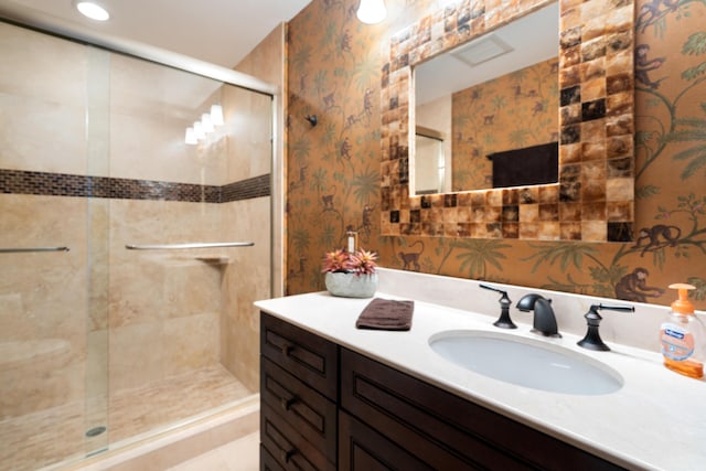 bathroom with a shower with door and vanity