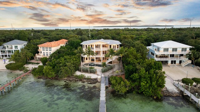 aerial view at dusk featuring a water view