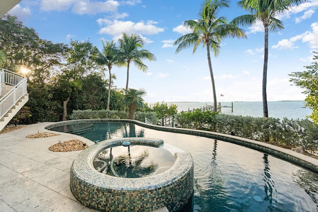 view of swimming pool featuring a water view and a patio area