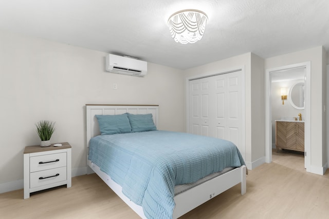 bedroom with a wall unit AC, a closet, and light wood-type flooring