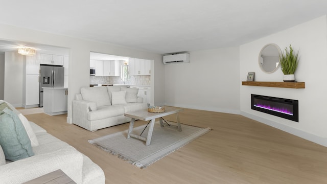 living room with light wood-type flooring and an AC wall unit