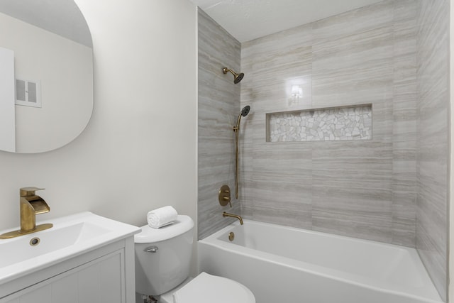 full bathroom with vanity, tiled shower / bath, and toilet