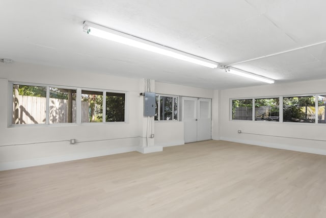 empty room with electric panel and light hardwood / wood-style floors