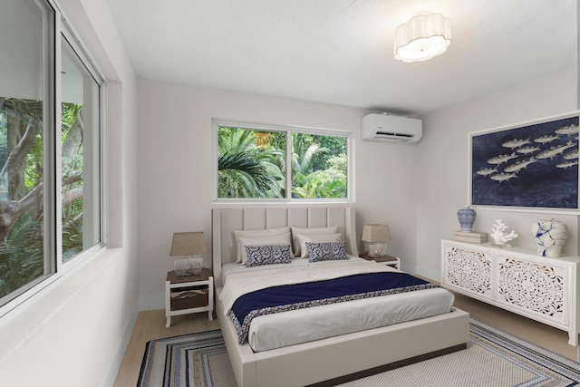 bedroom featuring wood-type flooring and a wall unit AC