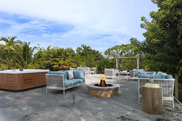 view of patio / terrace featuring an outdoor living space with a fire pit and a hot tub