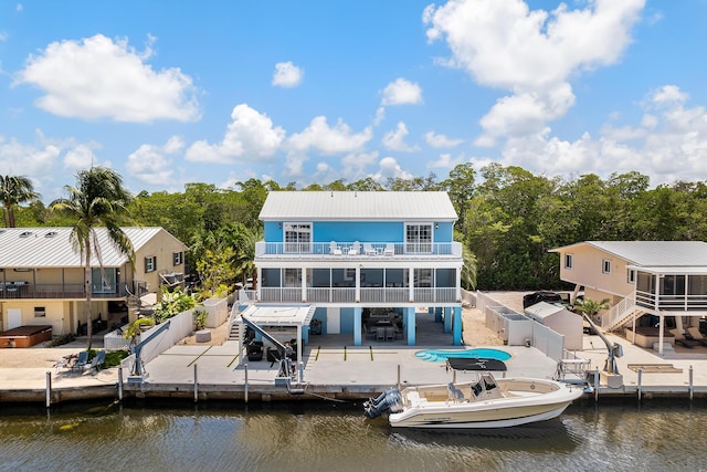 back of house featuring a balcony, a water view, and a patio area