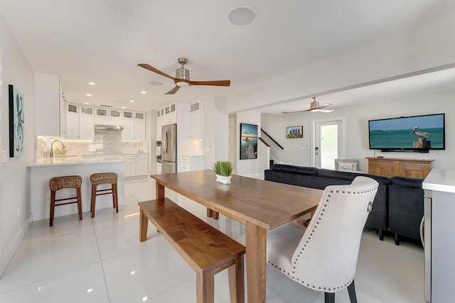 dining area featuring sink, ceiling fan, and light tile patterned flooring