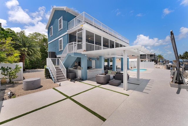 rear view of property featuring area for grilling, central AC unit, a fenced in pool, a sunroom, and a patio area