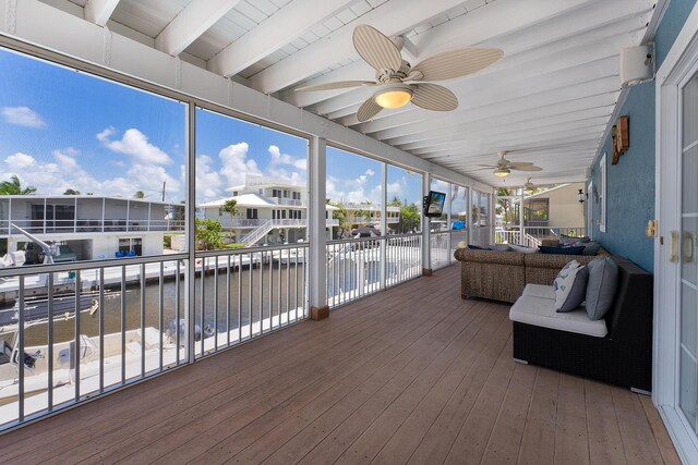 sunroom with beam ceiling and ceiling fan