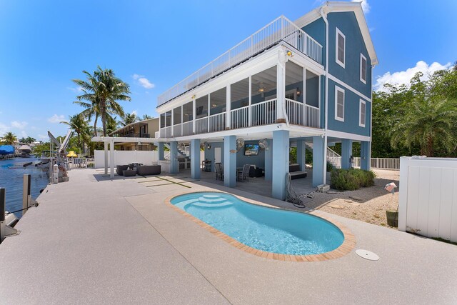 view of swimming pool featuring outdoor lounge area, a patio, and a sunroom