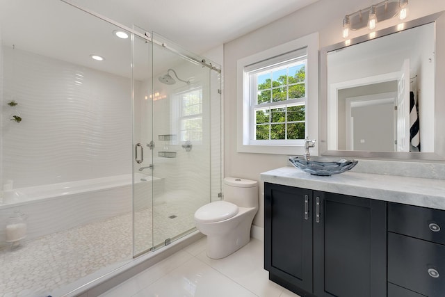 bathroom featuring walk in shower, vanity, tile patterned floors, and toilet