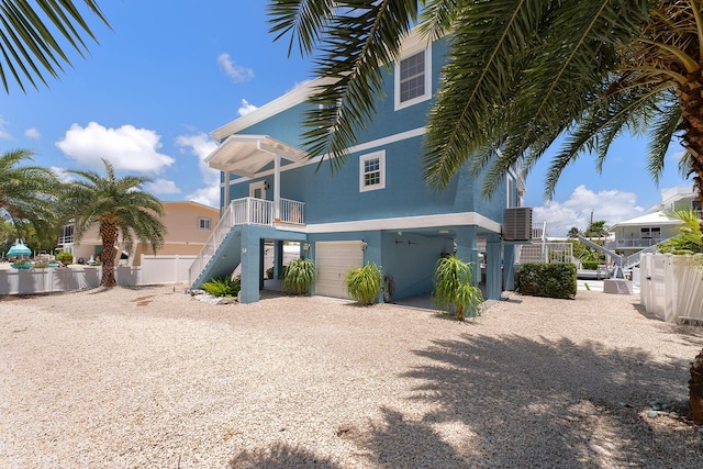 rear view of property featuring a garage and a balcony