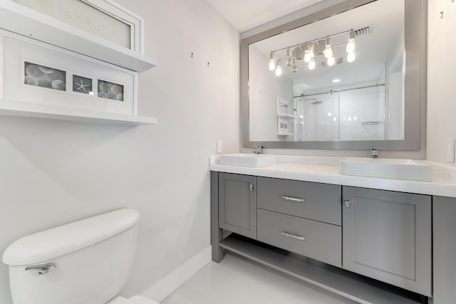 bathroom with toilet, vanity, and a shower with shower door