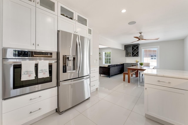 kitchen featuring light tile patterned floors, stainless steel appliances, white cabinets, and ceiling fan