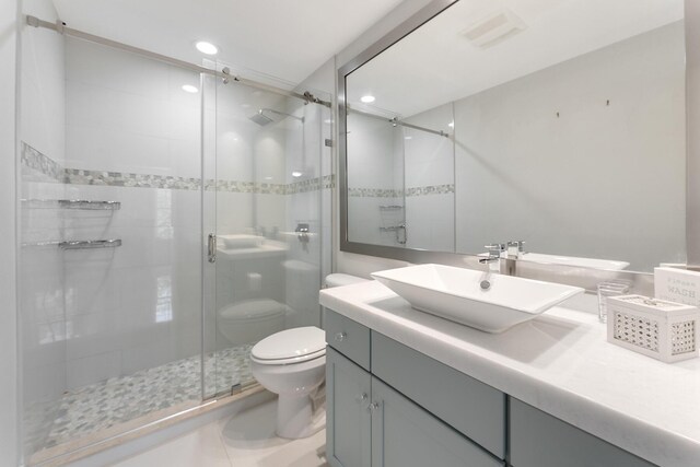 bathroom with an enclosed shower, vanity, and toilet