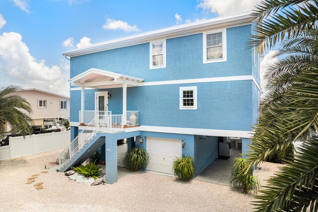 raised beach house featuring a garage and covered porch