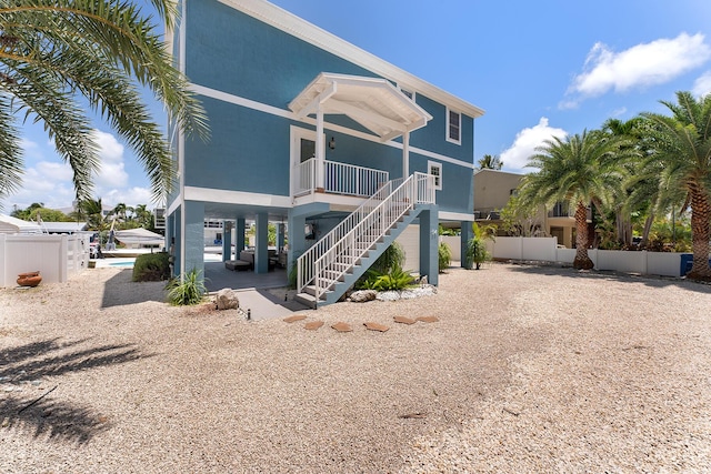 view of front facade with a swimming pool and a patio