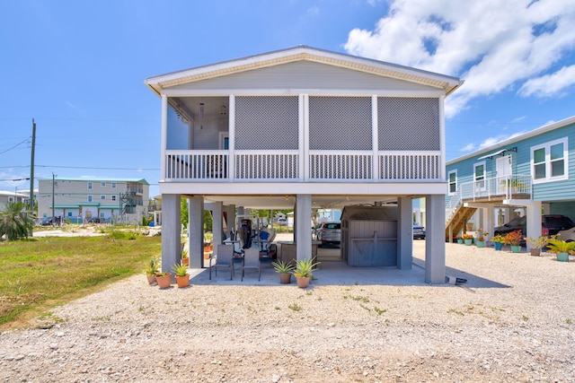480 E 105th Street Ocean St, Marathon, FL 33050 - view of front of home featuring stairway, a storage shed, a carport, a sunroom, and a patio area