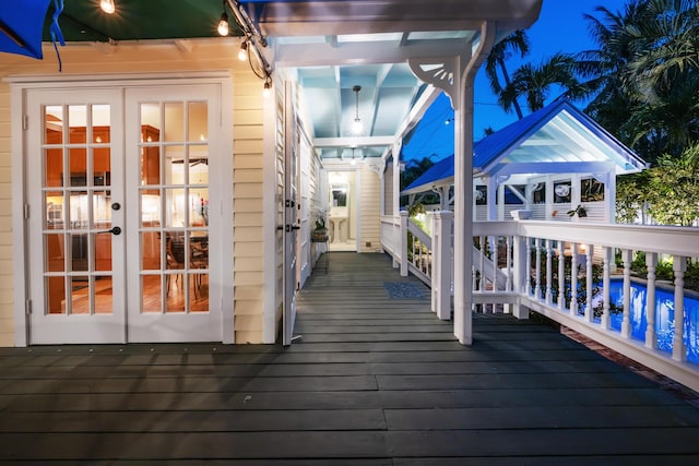 wooden terrace with french doors and an outdoor pool