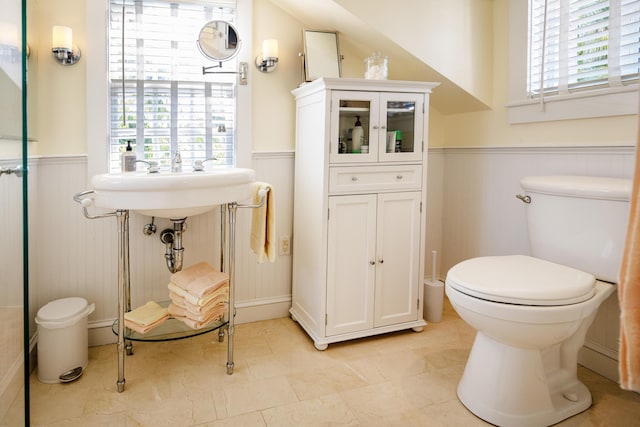 bathroom featuring toilet and wainscoting