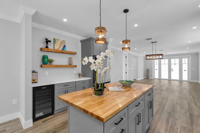 68 Coral Way, Key Largo, FL 33037 - kitchen featuring beverage cooler, gray cabinets, crown molding, wood counters, and hanging light fixtures