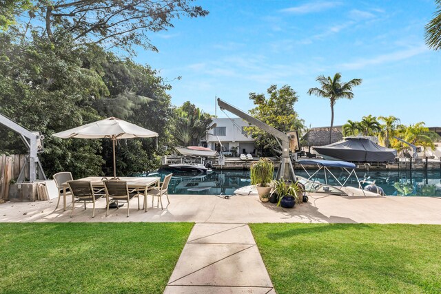 view of swimming pool featuring a patio, a water view, and a lawn