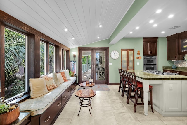 interior space with vaulted ceiling, light tile patterned floors, wood ceiling, and french doors