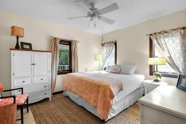 carpeted bedroom featuring multiple windows, ceiling fan, and a textured ceiling