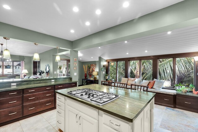 kitchen featuring white cabinetry, plenty of natural light, decorative light fixtures, and stainless steel gas cooktop