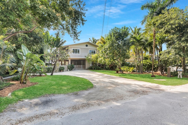 290 Woods Ave, Tavernier, FL 33070 - view of front of home with a balcony, curved driveway, and a front lawn