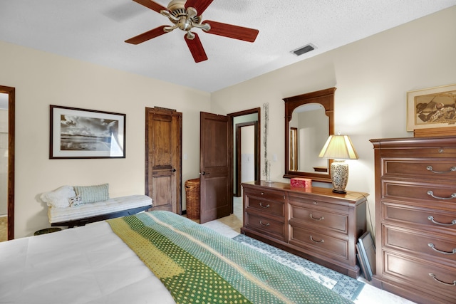 bedroom with ceiling fan and a textured ceiling