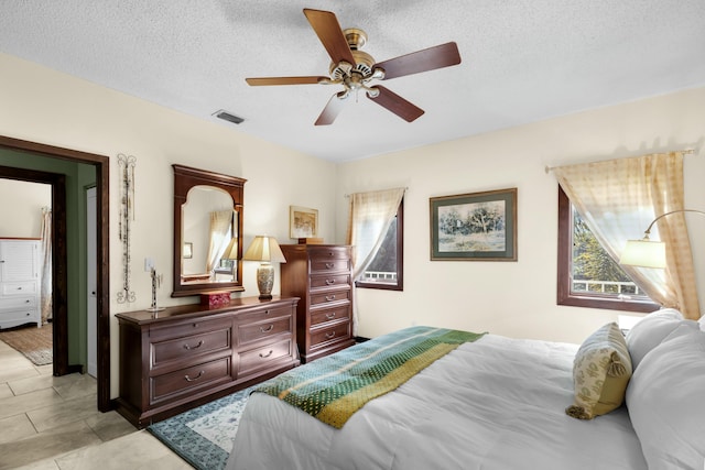 bedroom with ceiling fan and a textured ceiling