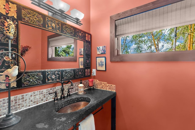 bathroom with a healthy amount of sunlight, sink, and backsplash