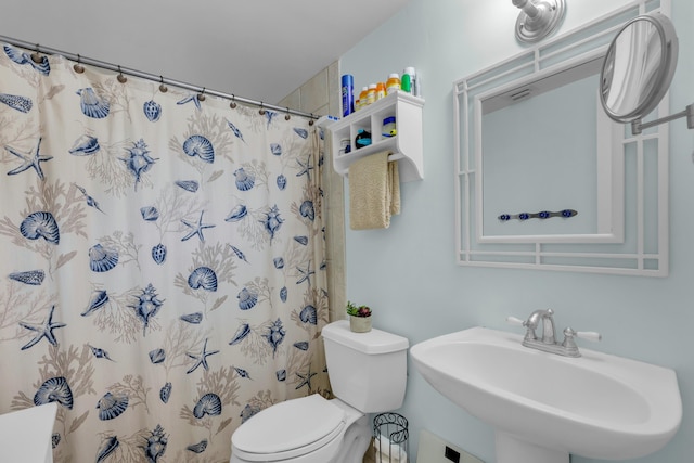 bathroom with sink, a shower with shower curtain, and toilet