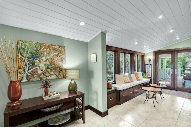 tiled living room with lofted ceiling and french doors