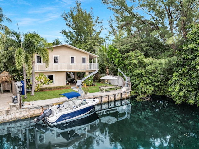 dock area with a water view, a patio area, and a lawn